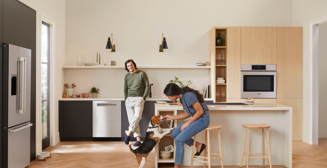 photo of family smiling in a modern kitchen with all brushed stainless steel appliances